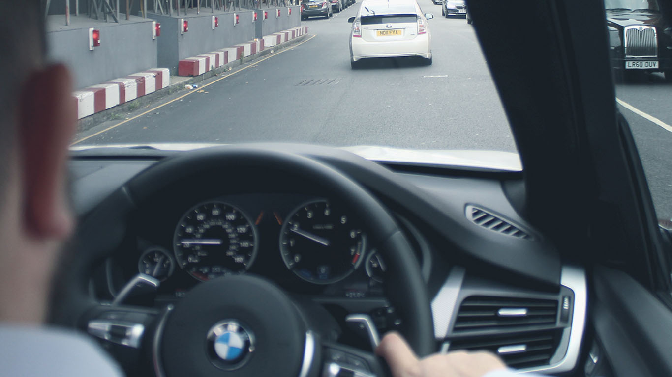 Over the shoulder BMW car surveillance with focus on drivers steering wheel